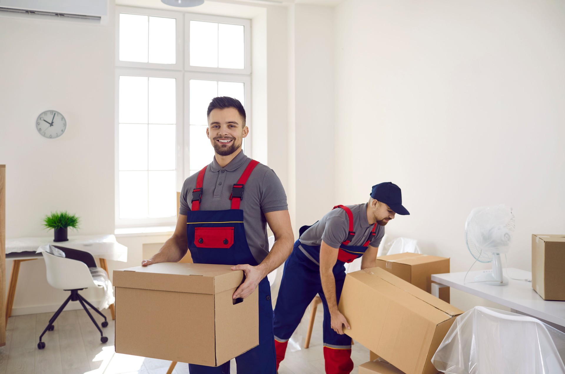 Smiling deliverymen working with packages at client home